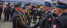 gratulacje przekazywane przez strażaków w mundurach wyjściowych koloru czarnego