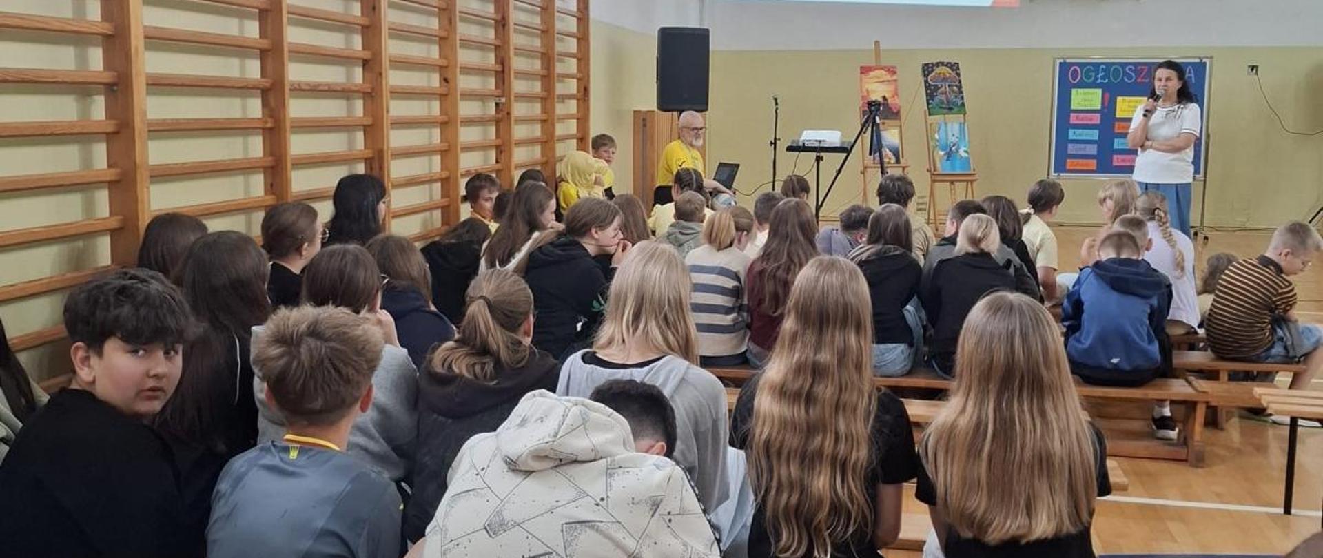 Przedstawicielka WSSE w Kielcach, która przedstawia zgromadzonym w sali gimnastycznej dzieciom podsumowanie programu „Trzymaj formę!”