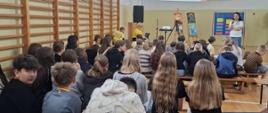 Przedstawicielka WSSE w Kielcach, która przedstawia zgromadzonym w sali gimnastycznej dzieciom podsumowanie programu „Trzymaj formę!”