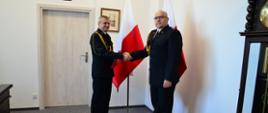 Pomorski komendant wojewódzki Państwowej Straży Pożarnej wręcza funkcjonariuszowi akt mianowania na wyższe stanowisko służbowe.