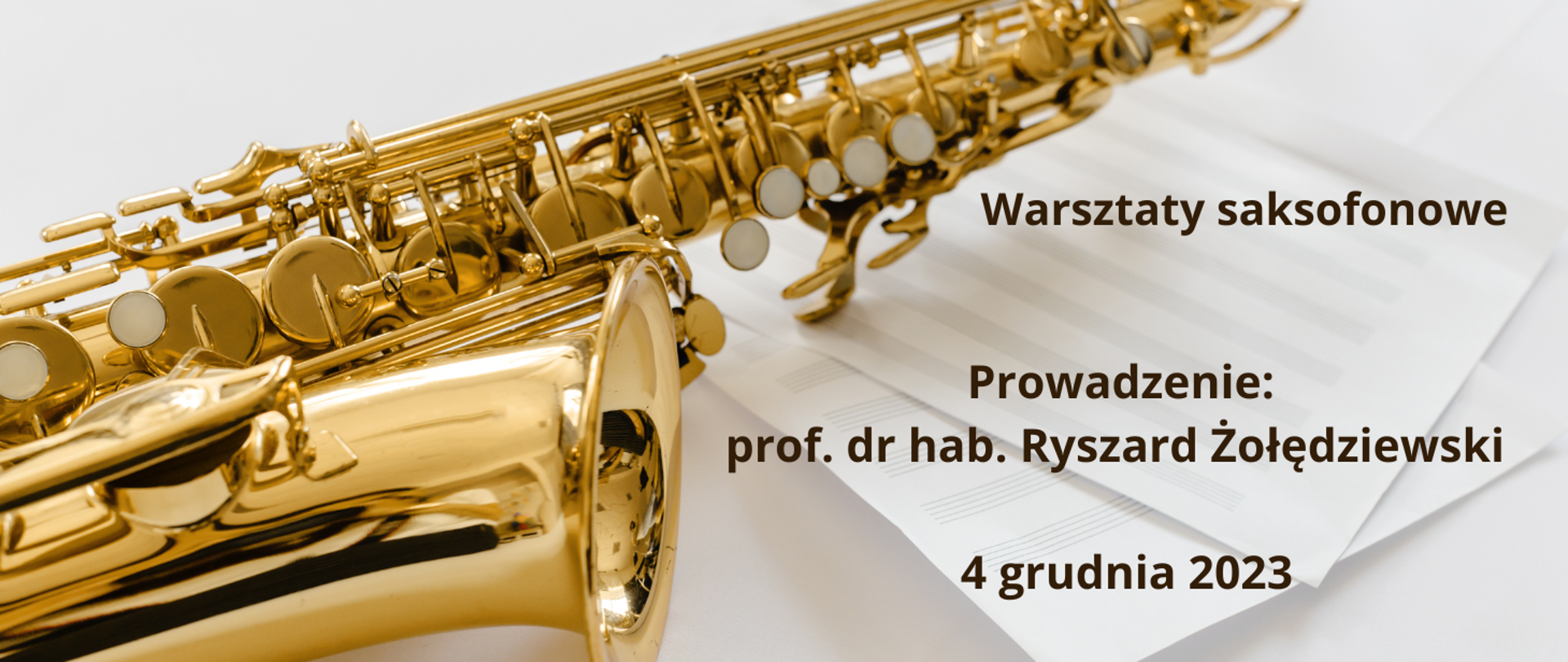 Złoty saksofon leżący na kartach papieru w pięciolinię. W prawej części planszy tekst w kolorze brązowym "Warsztaty saksofonowe, prowadzenie: prof. dr hab. Ryszard Zołędziewski, 4 grudnia 2023"