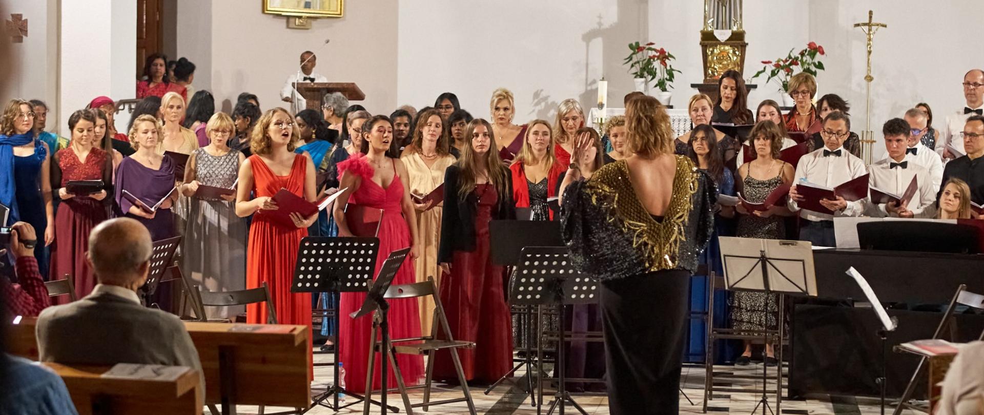 Pani Katarzyna Mąka-Żelazko dyryguje chór Concerto Glacensis w Kłodzkim Ośrodku Kultury w Kłodzku podczas uroczystości obchodów Międzynarodowego Dnia Muzyki