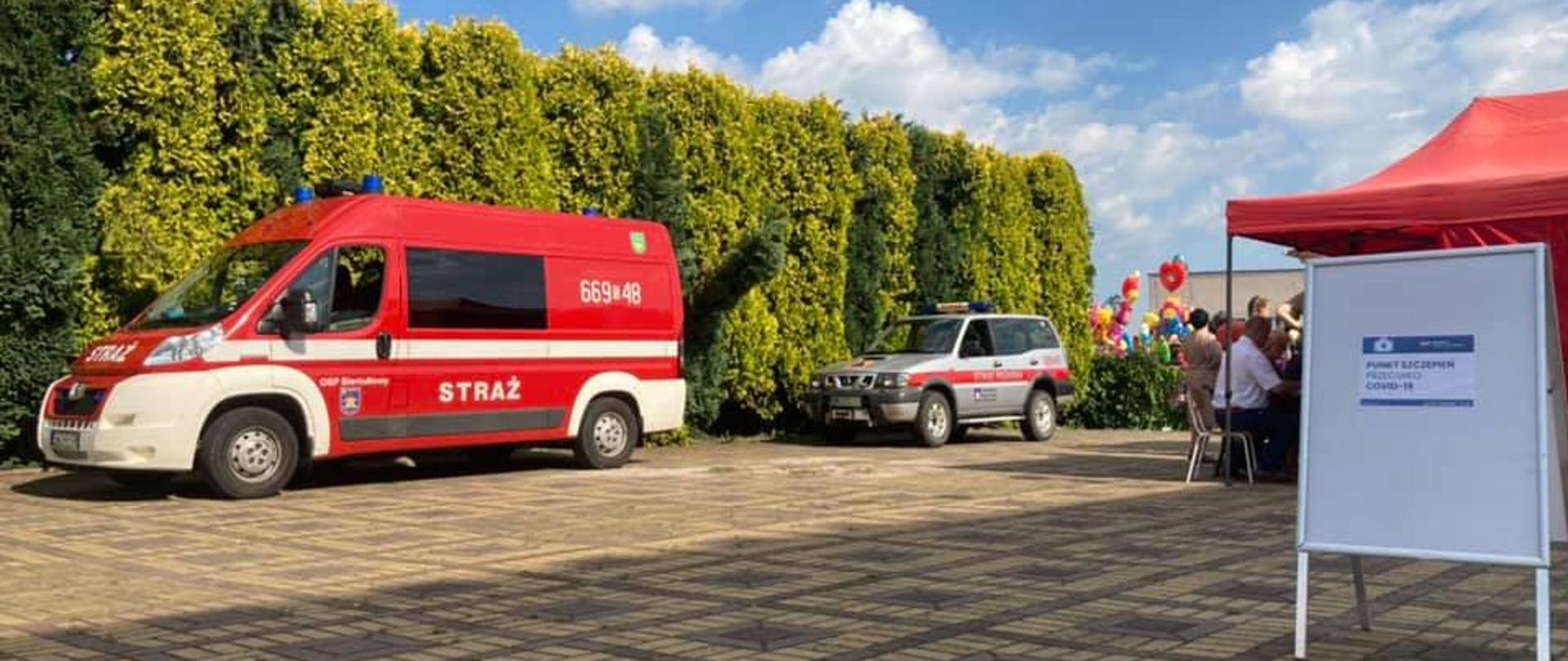 Na zdjęciu samochody strażackie na tle zabawy w plenerze