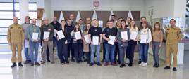 Pamiątkowe zdjęcie grupowe uczestników szkolenia inspektorów ochrony przeciwpożarowej (23 osoby) w towarzystwie dwóch funkcjonariuszy CS PSP oraz kobiety