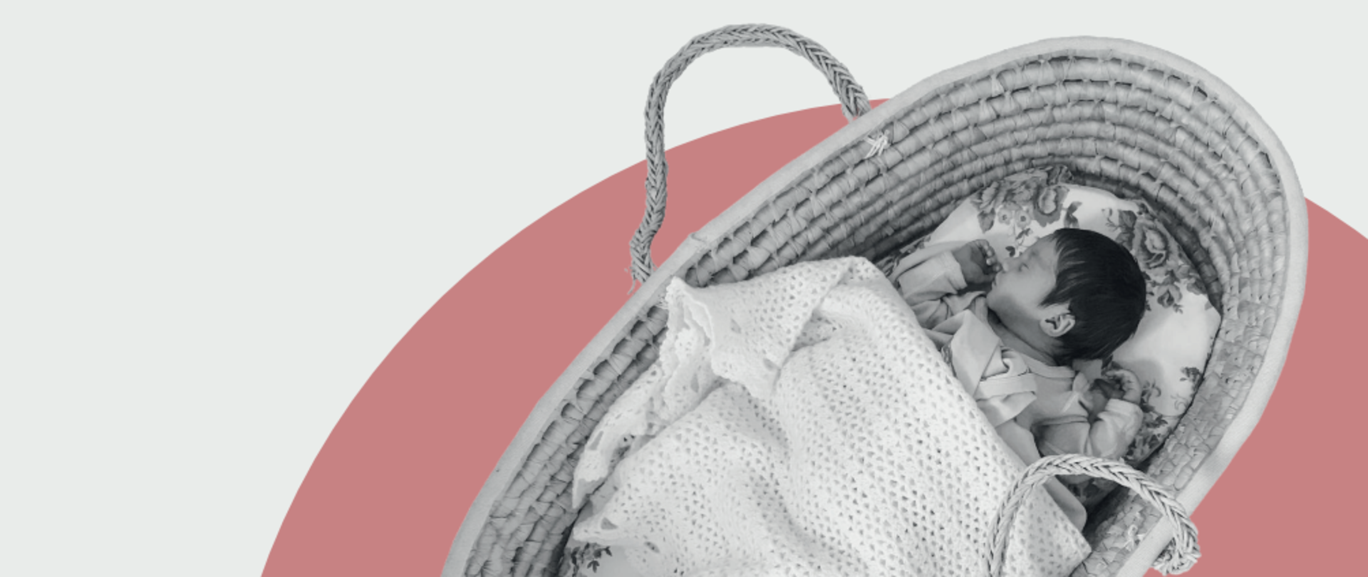 Niemowlę śpiące w koszu Mojżesza pod kocykiem na szaro różowym tle.