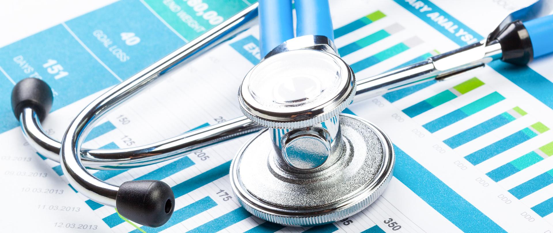 Stethoscope with financial on the desk.