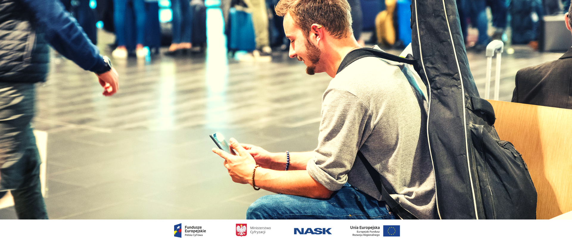 Mężczyzna z gitarą oraz telefonem komórkowym