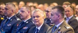Minister Tomasz Siemoniak siedzi na sali konferencyjnej w otoczeniu komendantów służb 