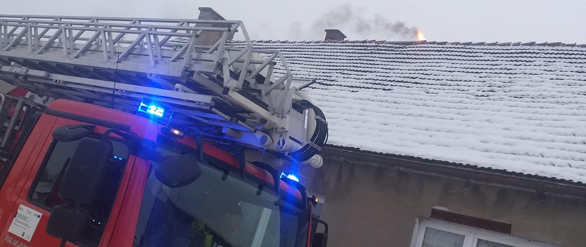 Zdjęcie przedstawia samochód SHD-23 na tle budynku z którego wydobywają się płomienie z komina