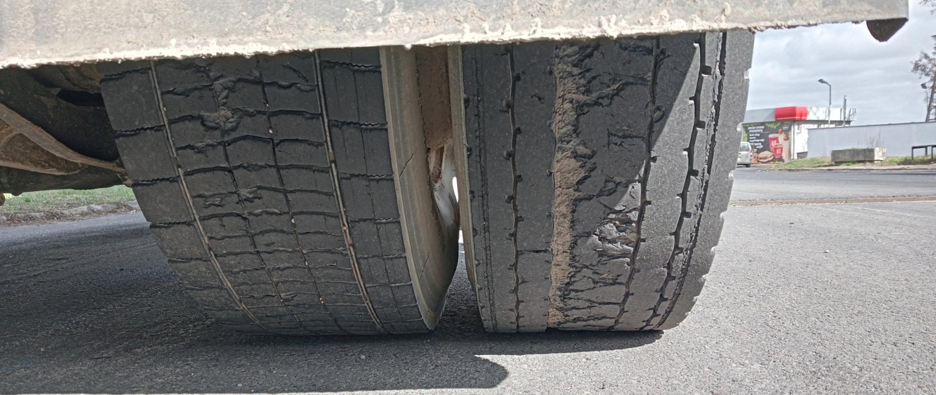 Zbliżenie na oponę z widocznymi licznymi uszkodzeniami