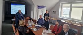 Zdjęcie przedstawia salę konferencyjną, w jej centralnej części przy stole siedzą pracownicy WIORiN w Kielcach uczestniczący w szkoleniu- trzy kobiety i trzech mężczyzn. Przy ekranie z wyświetloną prezentacją stoi Świętokrzyski Wojewódzki Inspektor Ochrony Roślin i Nasiennictwa Pan Edmund Kaczmarek. Po prawej stronie stołu stoi pani kierownik Działu Nadzoru Nasiennego