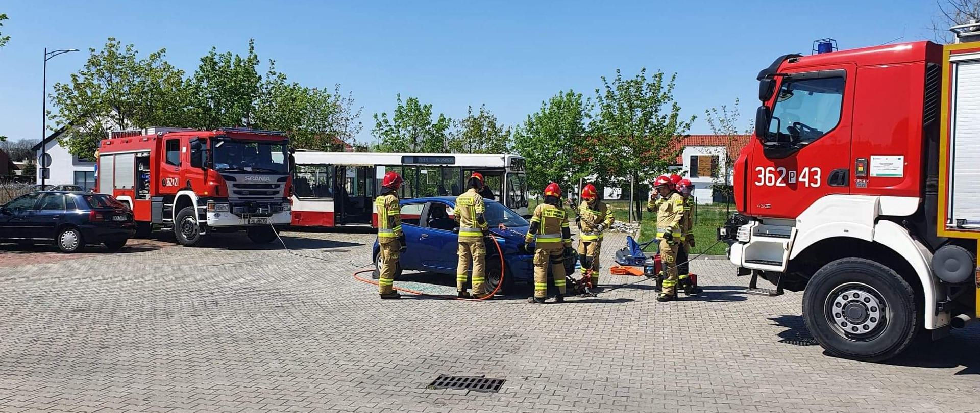 Zdjęcie przedstawia strażaków podczas ćwiczeń z zakresu ratownictwa technicznego. Strażacy przy pomocy urządzeń hydraulicznych oraz samochodów strażackich wykonywali dostęp do osoby poszkodowanej