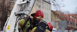 Strażacy JRG Śrem podczas ewakuacji poszkodowanej osoby z budynku klubu garnizonowego