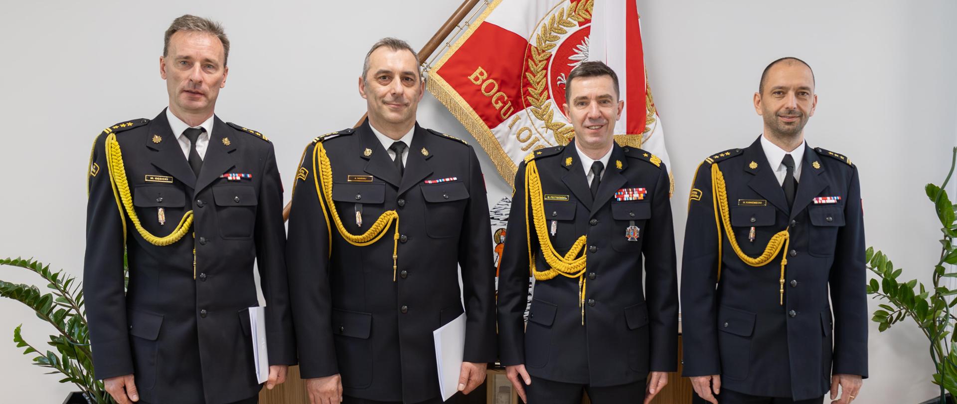 Czterech oficerów PSP pozuje do pamiątkowej fotografii po powołaniu dwóch zastępców warmińsko-mazurskiego komendanta wojewódzkiego PSP. Na zdjęciu od lewej dwóch zastępców komendanta wojewódzkiego PSP, komendant główny PSP oraz warmińsko-mazurski komendant wojewódzki PSP.