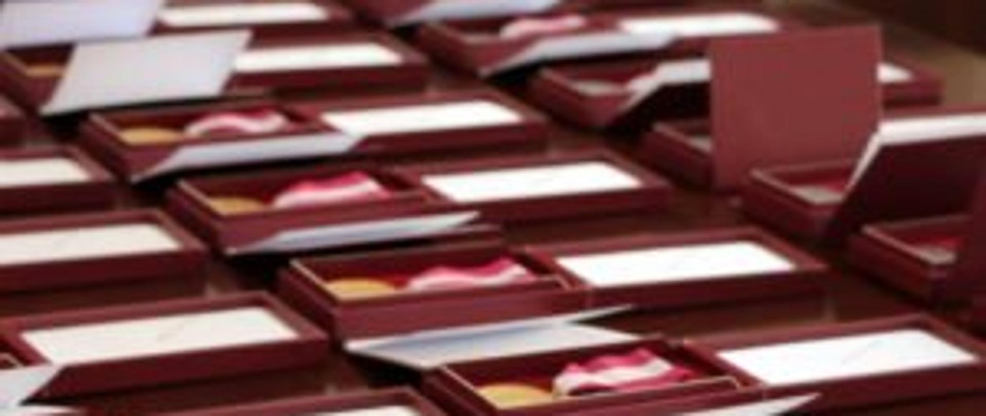 Odznaczenia państwowe leżące w ozdobnych opakowaniach 