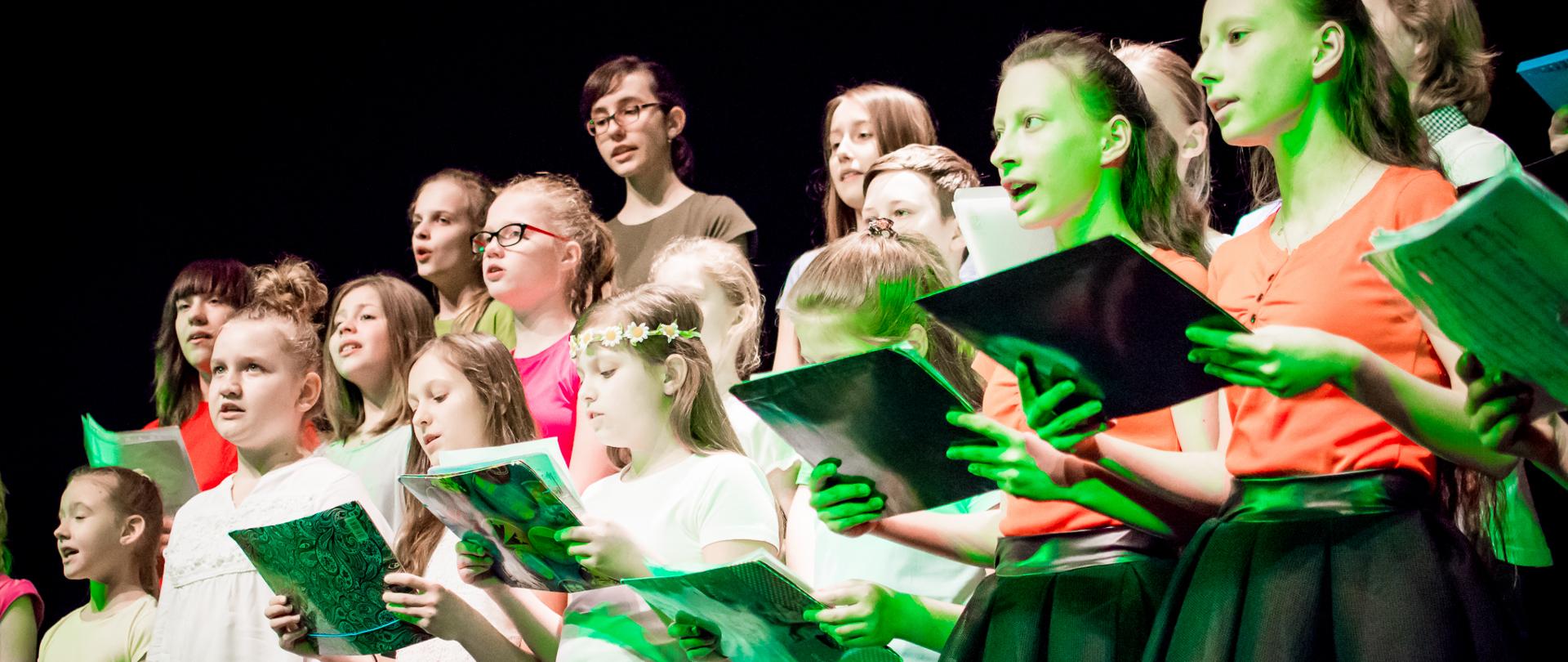 Uczniowie w chórze szkolnym śpiewający na występie