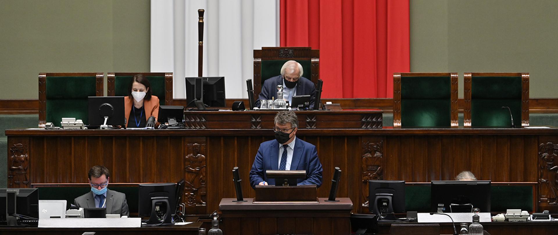 Na zdjęciu widać wiceministra Macieja Wąsika zabierającego głos z mównicy sejmowej.