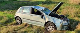Na zdjęciu wrak pojazdu. Pojazd osobowy. Na zielonej trawie. Zdjęcie wykonane w ciągu dnia. Okres letni.