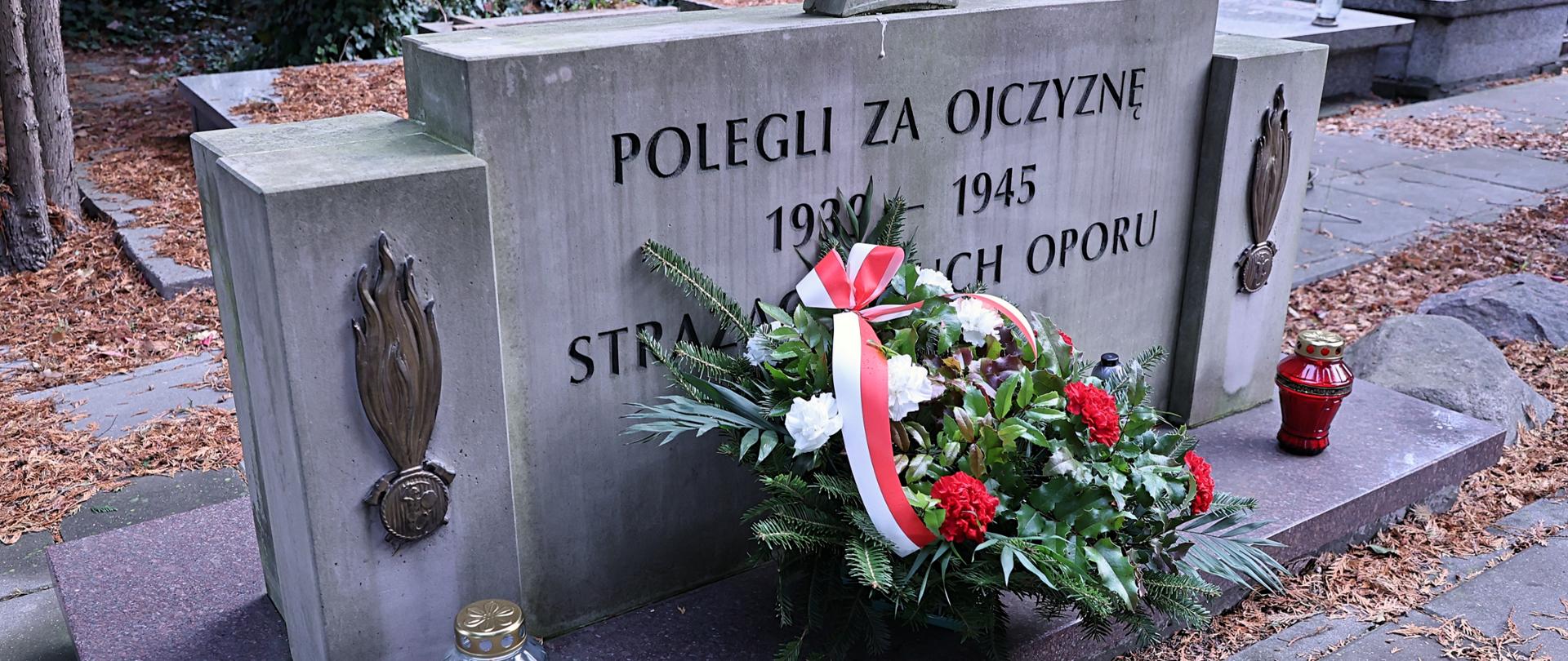 Wiązanka kwiatów złożona na grobie zasłużonych strażaków 