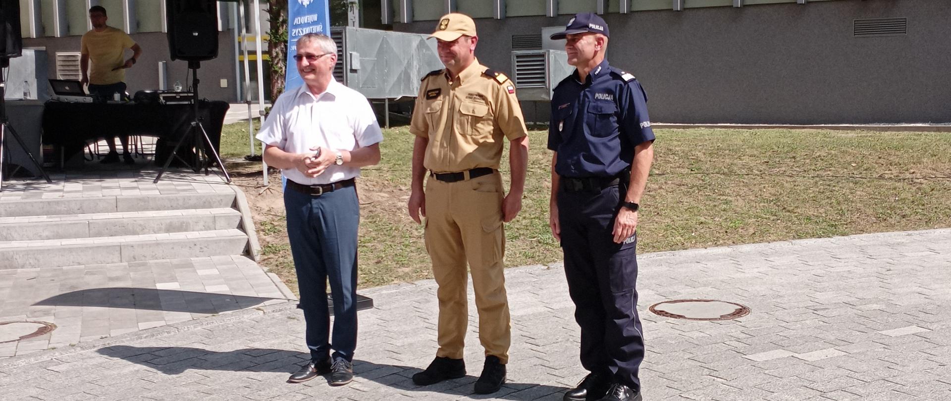 Zdjęcie przedstawia chwilę otwarcia pikniku. Od lewej stoją: Wojewoda Świętokrzyski Zbigniew Koniusz, Świętokrzyski Komendant Wojewódzki Państwowej Straży Pożarnej nadbryg. Krzysztof Ciosek i Komendant Wojewódzki Policji nadinsp. Jarosław Kaleta