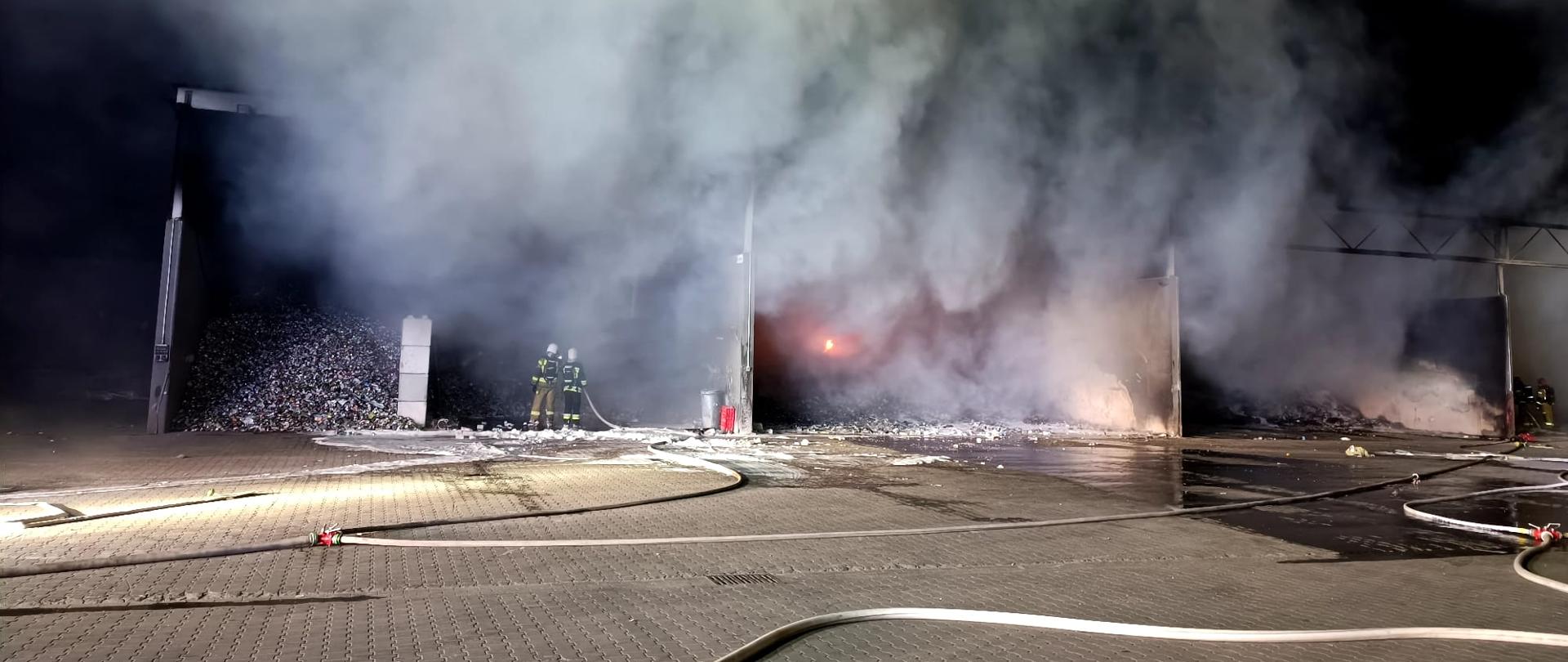 Strażacy gaszą płonący magazyn.