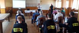 Zdjęcie przedstawia spotkanie z druhami OSP oraz osobami zainteresowanymi. Na zdjęciu widzimy druhów OSP oraz przedstawicieli Komendy Powiatowej Państwowej Straży Pożarnej w Ostrzeszowie, którzy przedstawiają projekt ustawy OSP. Zdjęcie wykonane w pomieszczeniu w porze dziennej.