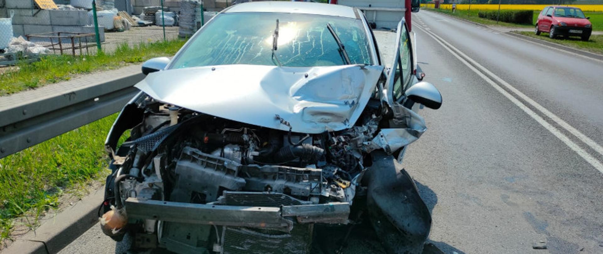 Zdjęcie przedstawia samochód osobowy po wypadku ze zniszczonym przodem