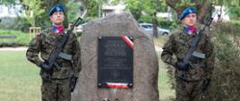 Dwóch żołnierzy stojących przy pomniku