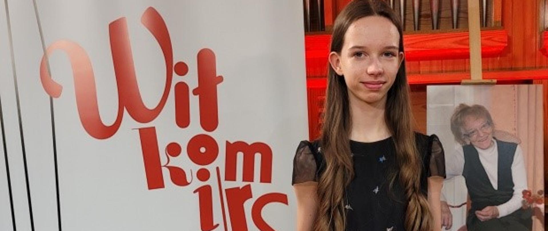 Na zdjęciu Emilia Linka z dyplomem Konkursu Skrzypcowego. W tle biały baner Konkursu Muzyki Skrzypcowej w Częstochowie.