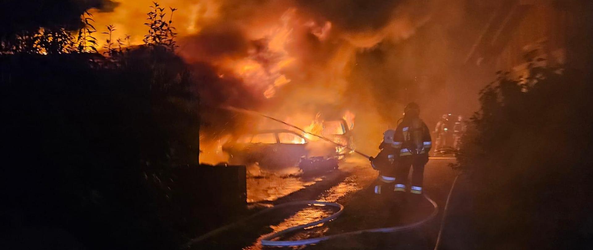 Strażacy gaszą pożar budynku gospodarczego.