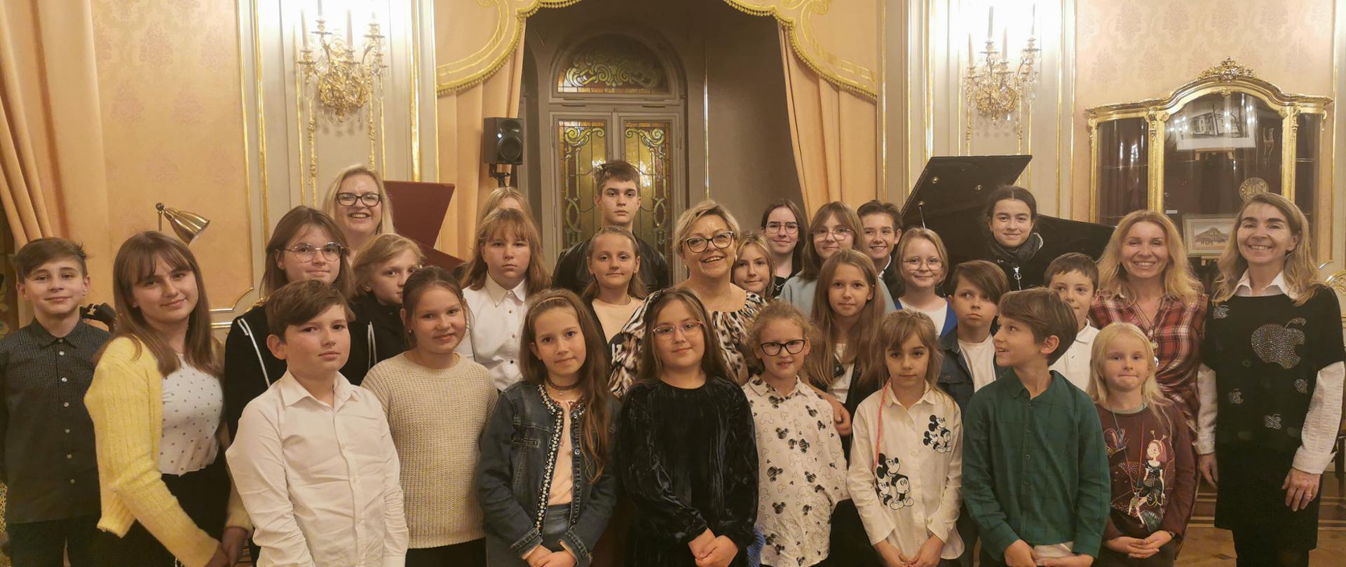 zdjęcie grupowe przedstawiające uczniów i nauczycieli w sali koncertowej