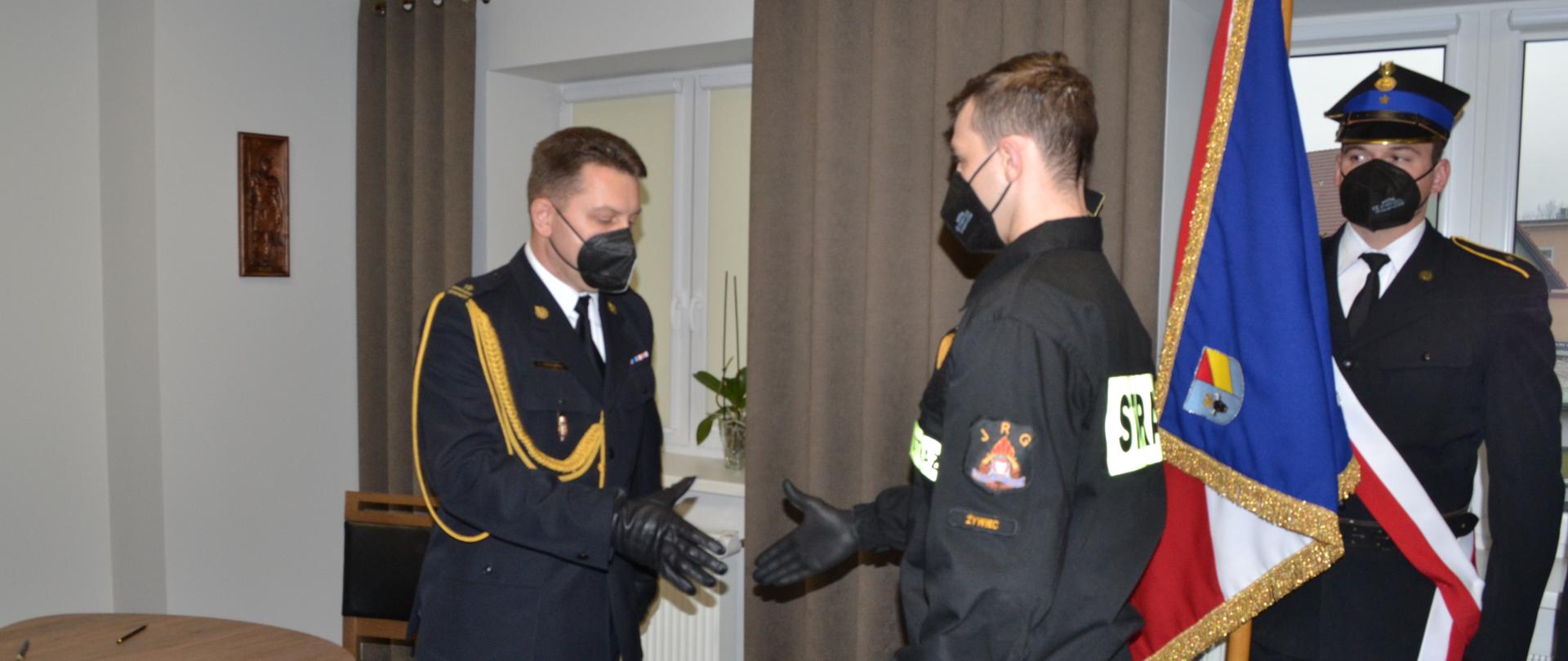Komendant Powiatowy PSP w Żywcu wręcza akt ślubowania oraz gratuluję strażakowi. 