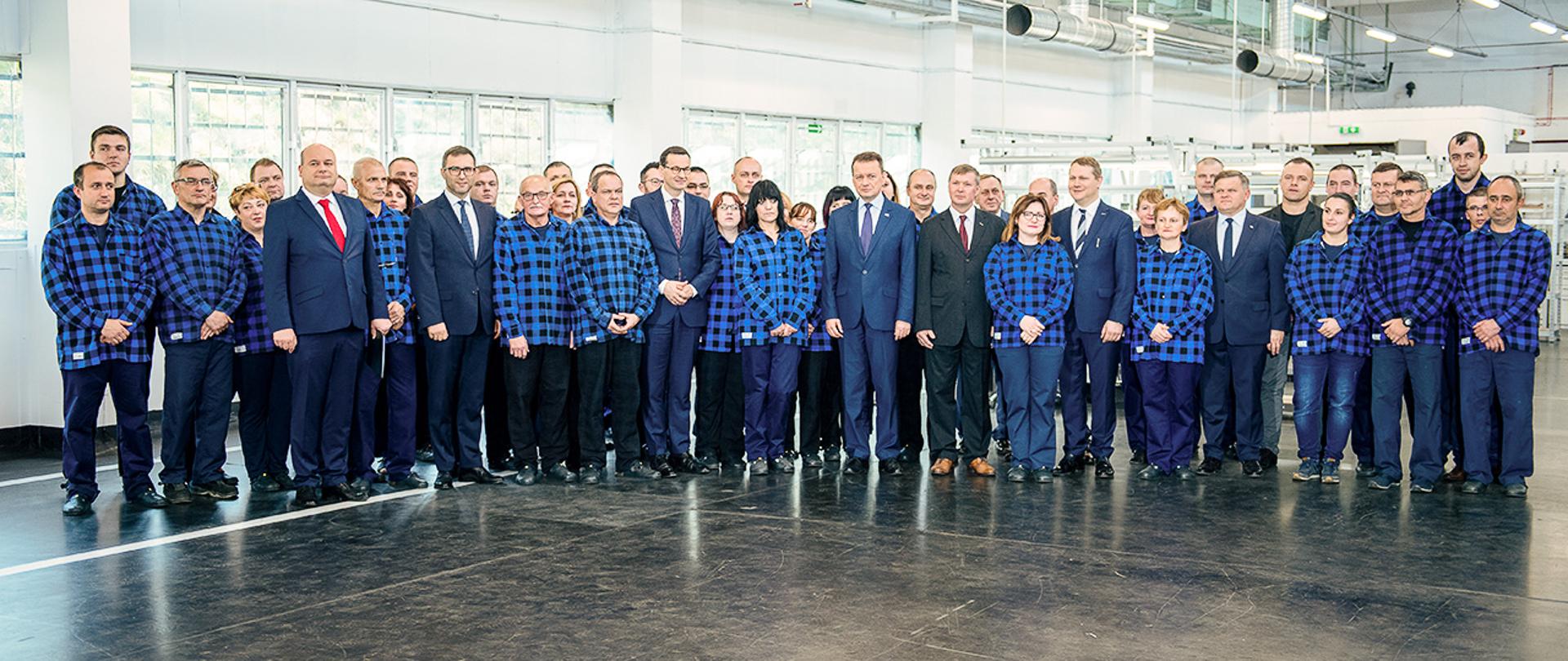 Premier Mateusz Morawiecki i minister Mariusz Błaszczak na spotkaniu z grupą pracowników w siedzibie spółki Mesko. 