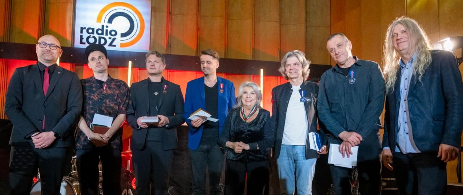 Pamiątkowa fotografia dyrektora biura wojewody Tobiasza Puchalskiego z uhonorowanymi artystami. 