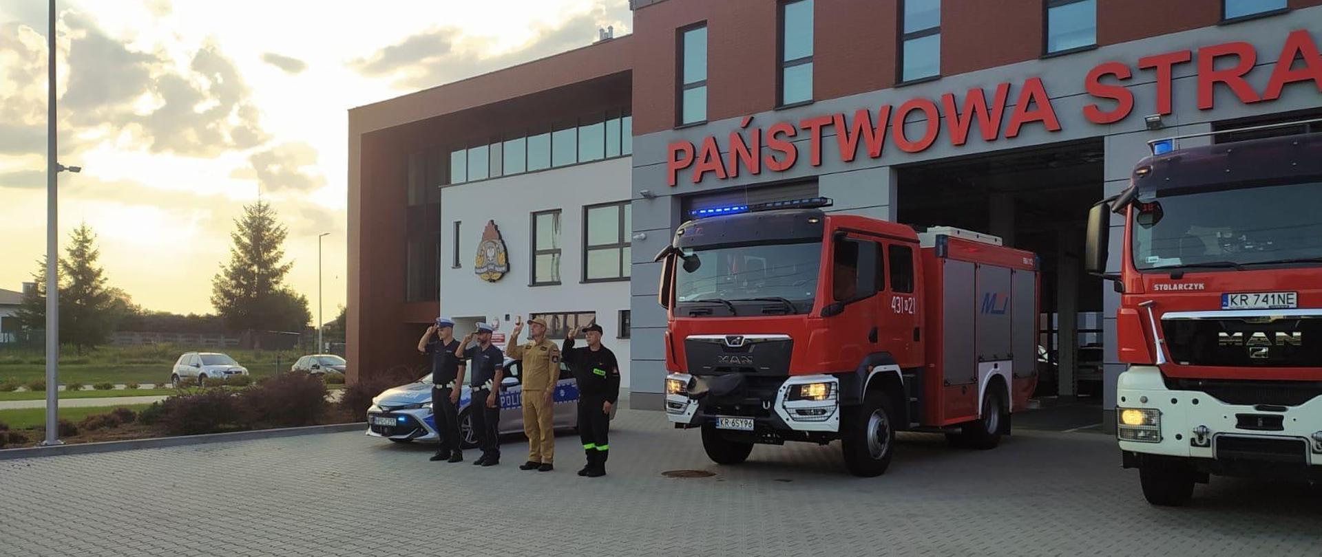Na zdjęciu strażacy i policjanci przed budynkiem komendy