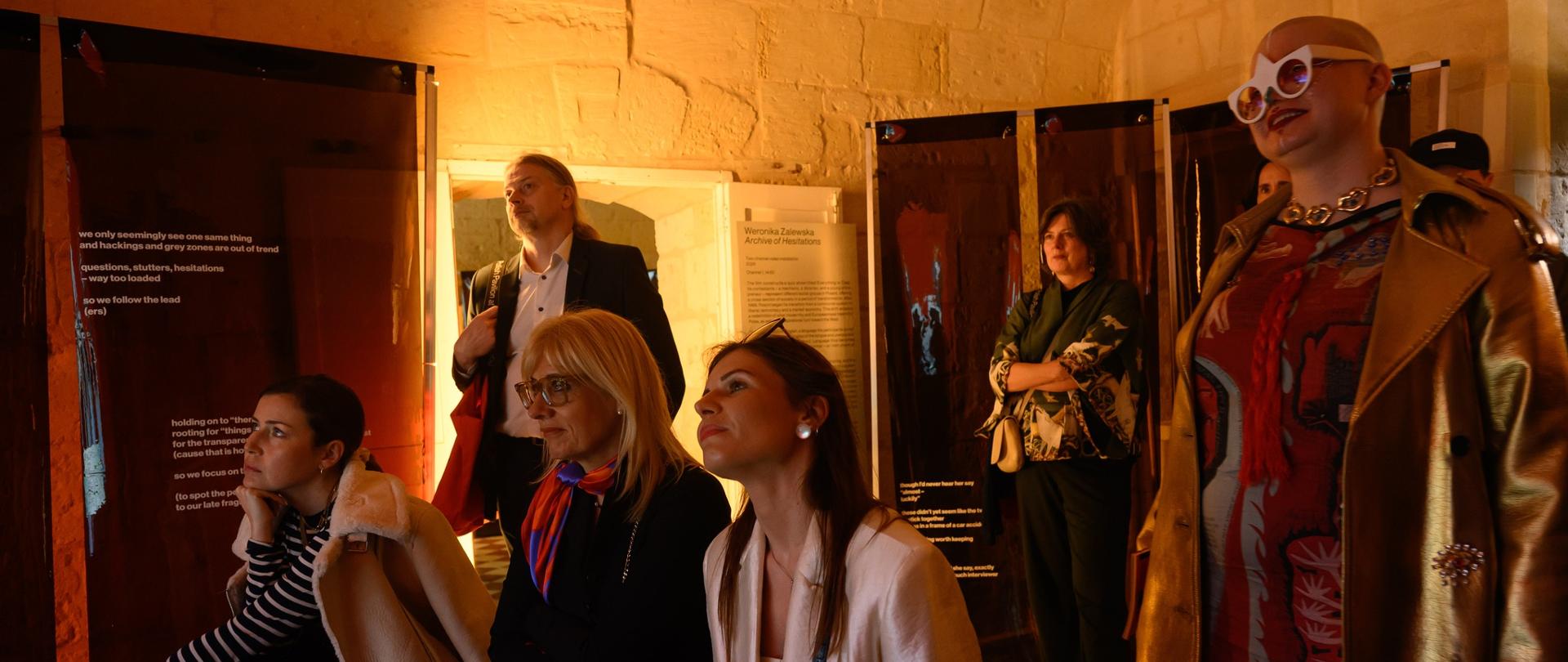 A group of women watching television films in the Polish pavilion during the Malta Art Biennale.