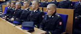 Kadeci w umundurowaniu galowym siedzący w auli CS PSP podczas uroczystości rozpoczęcia roku szkolnego