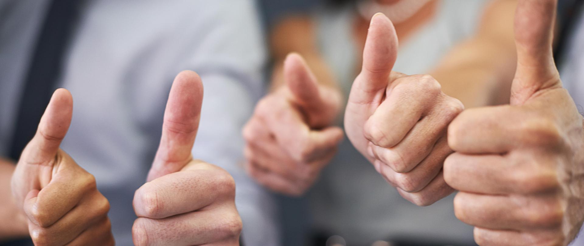 Thats a winning strategy. Closeup shot of a group of professional coworkers giving thumbs up