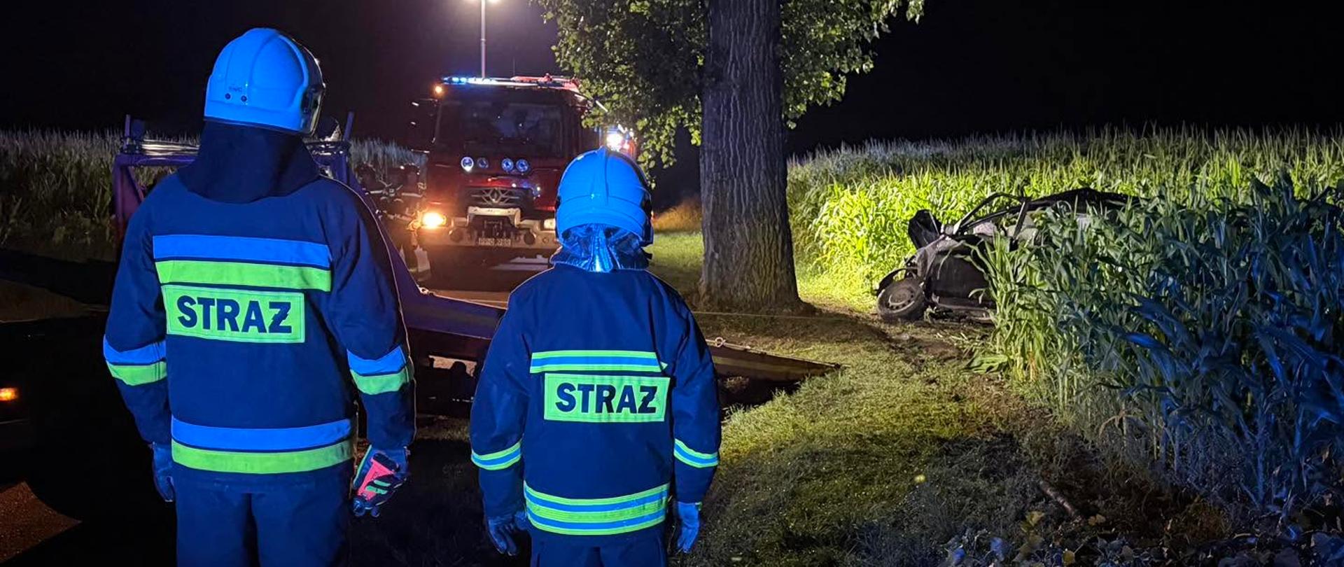 Na zdjęciu widnieją strażacy w trakcie działań ratowniczych podczas wypadku drogowego. 
