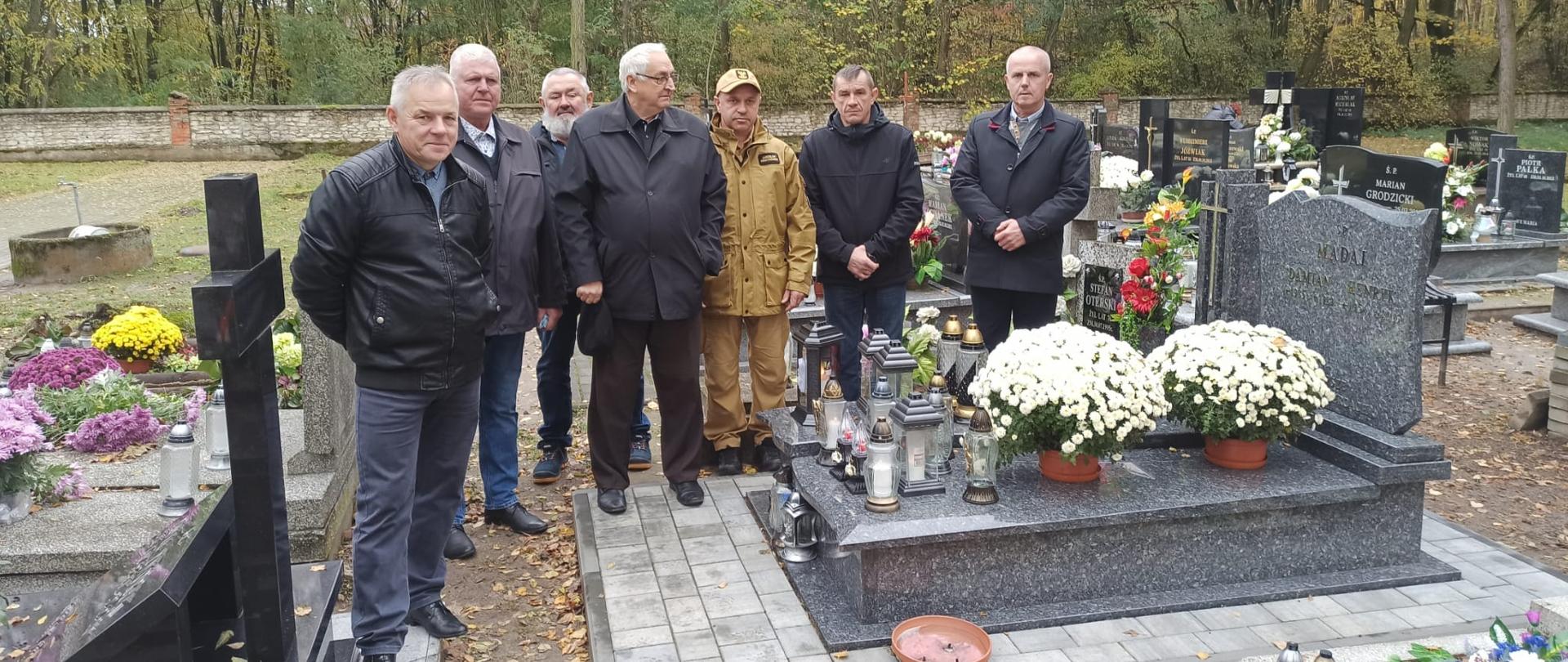 przy grobie stoi 7 mężczyzn 