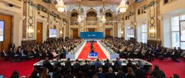 The photo depicts the plenary hall of the 32nd OSCE Ministerial Council, 4-5 December 2025 in Vienna