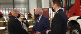 Zdjęcie przedstawia Wojewodę Lubuskiego, który wręcza akt przekazania nowego samochodu ratowniczo-gaśniczego.