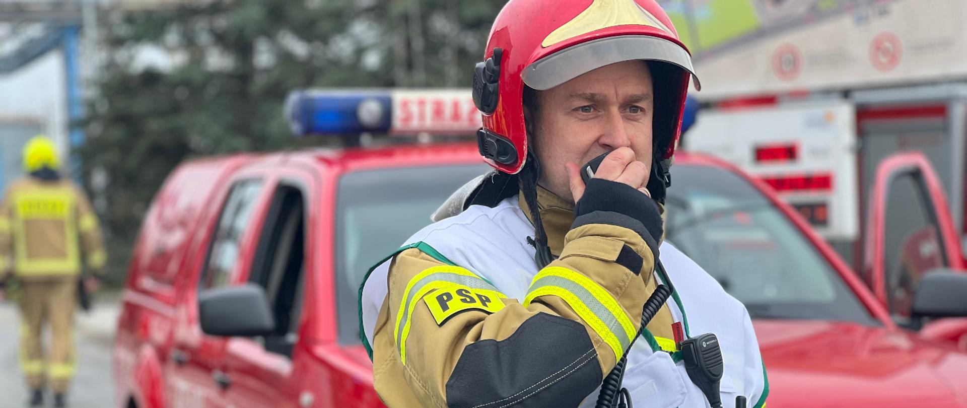 Dowódca akcji w kamizelce prowadzi łączność