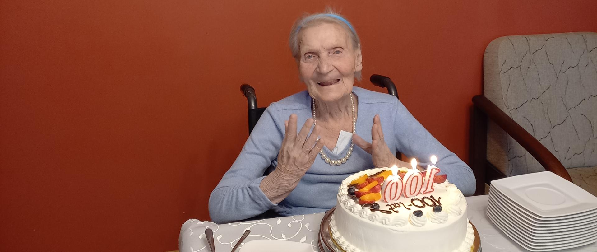 Uśmiechnięta Jubilatka przy urodzinowym torcie