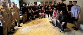 Pamiątkowe zdjęcie grupowe wychowanków Domu Dziecka wraz z wychowawcami i przybyłymi w odwiedziny strażakami