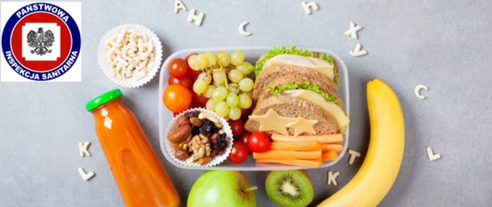 Szkolne pudełko na lunch z warzywami, owocami i kanapką na kuchennym stole widokowym