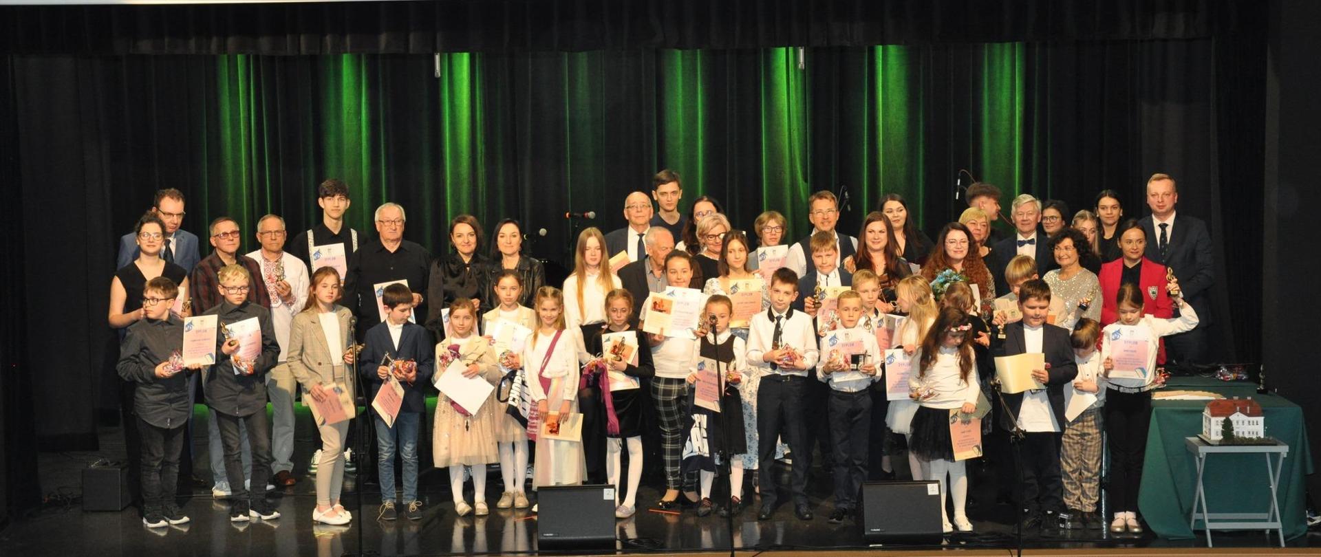 Wszyscy uczestnicy koncertu na scenie sali widowiskowej Centrum Kultury i Rekreacji we Wschowie. 