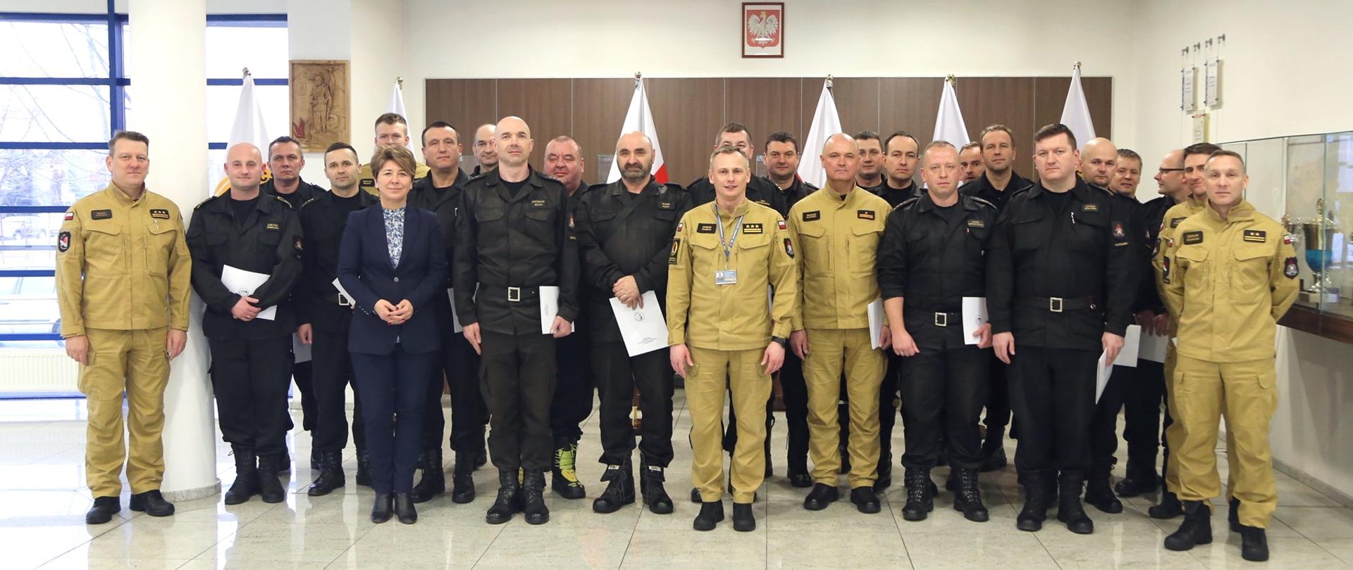 Grupowe zdjęcie uczestników warsztatów w towarzystwie Zastępcy Komendanta Centralnej Szkoły PSP oraz kobiety