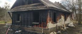 Czesciowo spalony dom drewniany.
