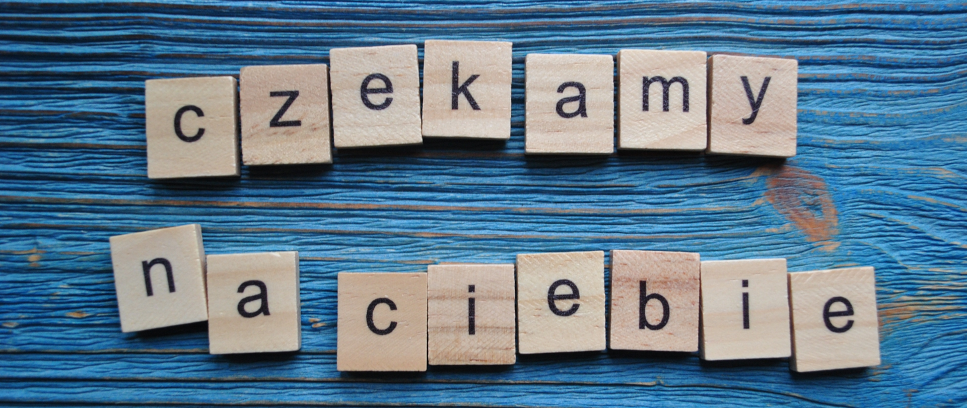 Baner dnia otwartego w Państwowej Szkole Muzycznej I stopnia nr 5 imienia Henryka Wieniawskiego w Warszawie. Na niebieskim tle napis "Czekamy na Ciebie" ułożony z drewnianych klocków.